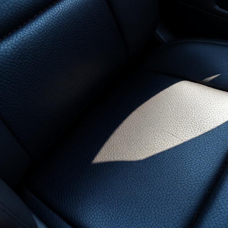 Faded and cracked leather car seat upholstery showing severe UV sun damage from unprotected windows.